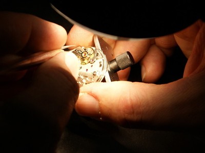 Link to article, picture is a person adjusting a hairspring